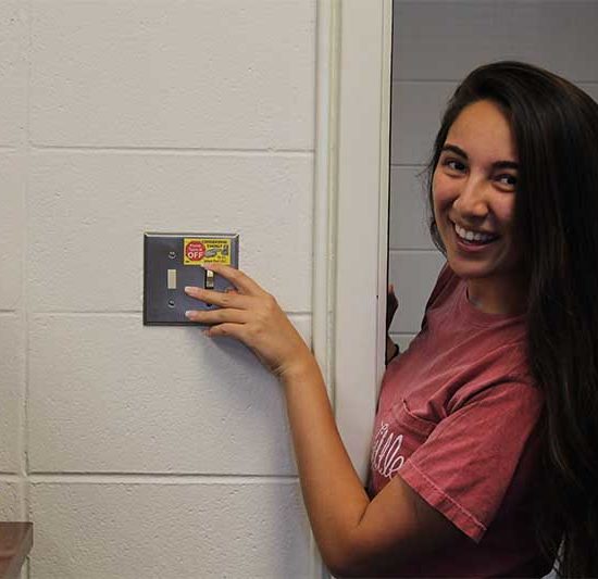 student turns off lights as she leaves the room