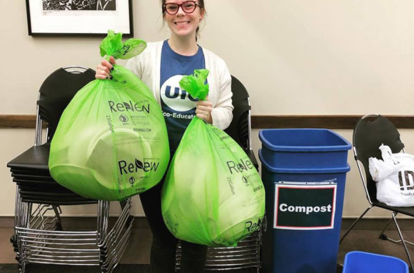 student holding up bags of compost