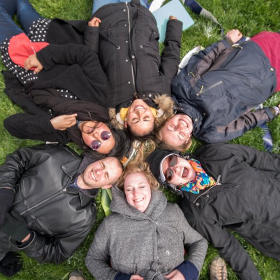 people laying down in the grass, smiling
