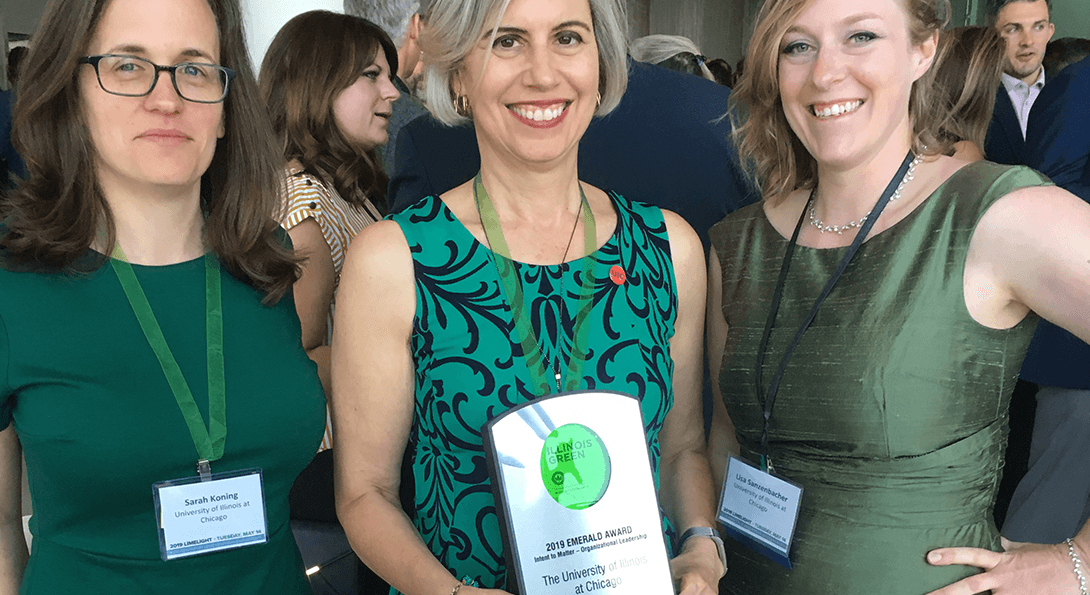 Sustainability staff proudly display thier Emerald Award plaque