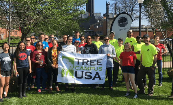 students and staff next to the Tree Campus USA banner