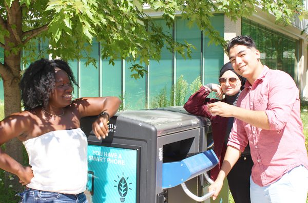 students recycling in outdoor bin