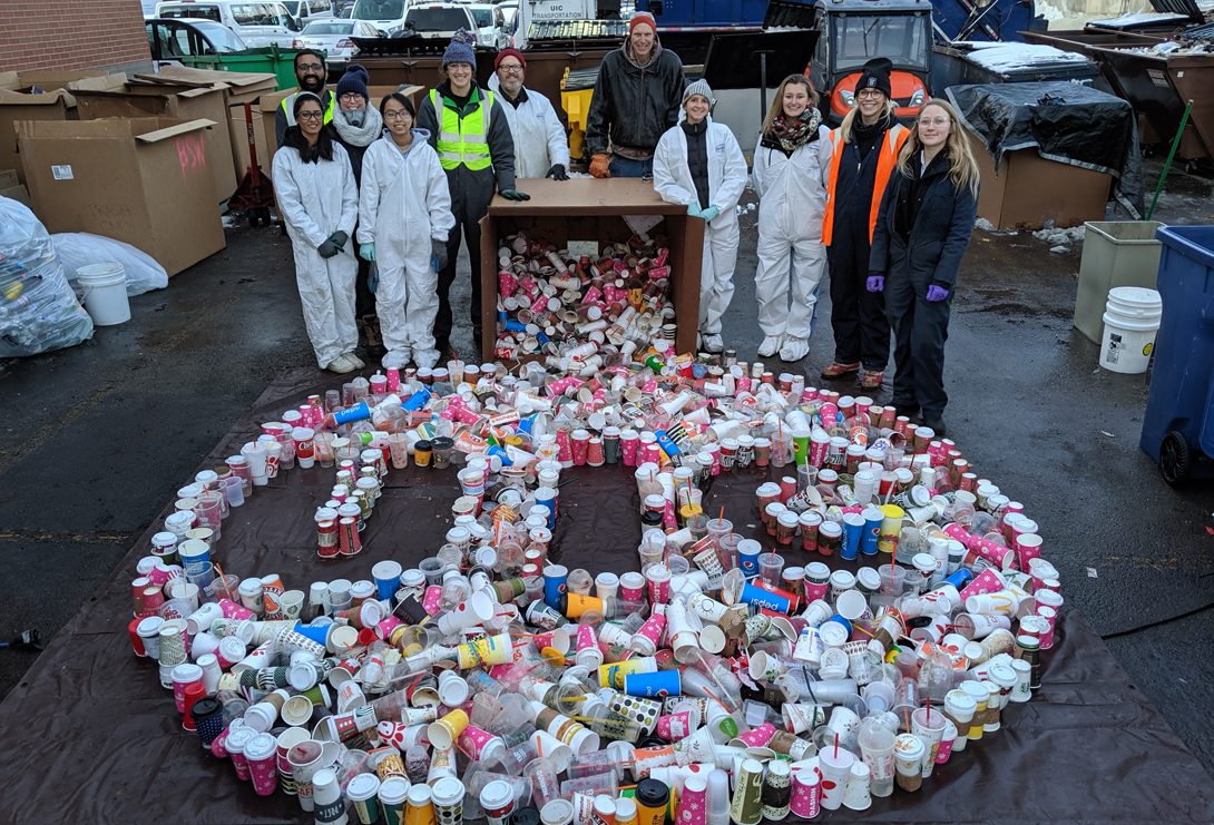 volunteers spell the UIC logo in single-use disposable beverage containers found at the waste audit.