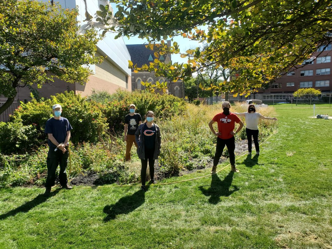 six SIP students and volunteers stand in front of the Little Prairie on the Campus During a prairie maintenance event in Fall 2020.