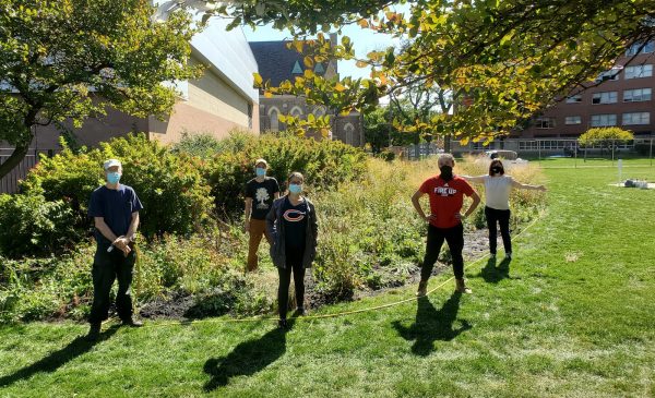 students and staff next to the Tree Campus USA banner